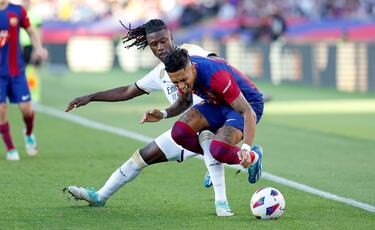 El futbolista del Real Madrid, Camavinga, pelea un balón con el jugador del Barcelona, Raphinha. 

