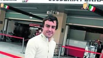 <b>CACHONDEO. </b>Alonso se ríe con el hecho de que le hagan fotos con el box de Ferrari detrás.