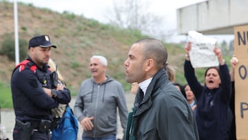 Prison workers unions' members protest over the killing of a cook by an inmate the week before, as convicted rapist and former Brazil international football player Dani Alves (R), leaves Brians 2 prison in San Esteban Sasroviras, near Barcelona, on March 25, 2024. Convicted rapist and former Brazil international Dani Alves left a jail in Barcelona on March 25, 2024 after posting the one-million-euro bail set by a Barcelona court to ensure his release pending appeal. Ex-Brazil star has been sentenced to 4.5 years in jail for rape on February 22, 2024. (Photo by LLUIS GENE / AFP)