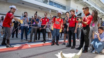 Ferrari's Monegasque driver Charles Leclerc (L), with Ferrari's Spanish driver Carlos Sainz Jr. (55), tries to lasso at cow skull in the paddock ahead of the United States Formula One Grand Prix at the Circuit of the Americas in Austin, Texas