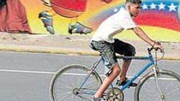 <b>PARAFERNALIA. </b>Un ciclista pasa en Caracas ante un cartel de la Copa América vinculado a Chávez.