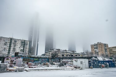 Vista de las Cuatro Torres cubiertas por niebla, desde la estación de CHamartín, cubierta de nieve.