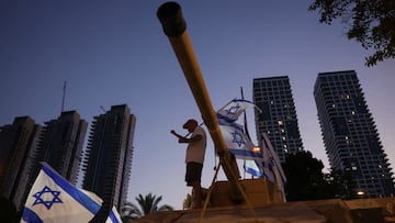 A protester stands atop a representation of a tank, during a demonstration against Israeli Prime Minister Benjamin Netanyahu's government and a call for the release of hostages in Gaza, amid the Israel-Hamas conflict, in Tel Aviv, Israel, July 20, 2024. REUTERS/Ricardo Moraes