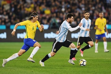 Filipe Luis persigue a Messi.