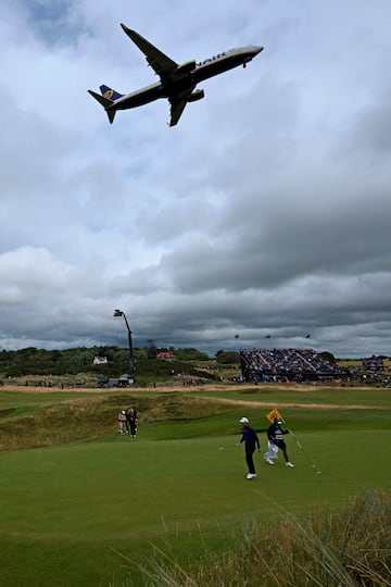 Un avión de Ryanair sobrevuela durante el despegue el octavo green del British Open de golf en su segundo día de competición en Troon (Escocia). La proximidad entre el Royal Troon Golf Club y el aeropuerto permite ver imágenes como esta.