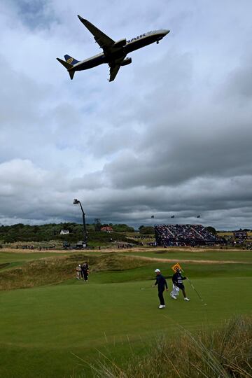 Un avión de Ryanair sobrevuela durante el despegue el octavo green del British Open de golf en su segundo día de competición en Troon (Escocia). La proximidad entre el Royal Troon Golf Club y el aeropuerto permite ver imágenes como esta.