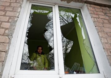 Una mujer observa los daños de su casa en la región de Donetsk.