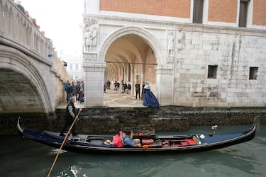 Un gondolero rema su góndola durante una fuerte marea baja en la ciudad laguna de Venecia, Italia.