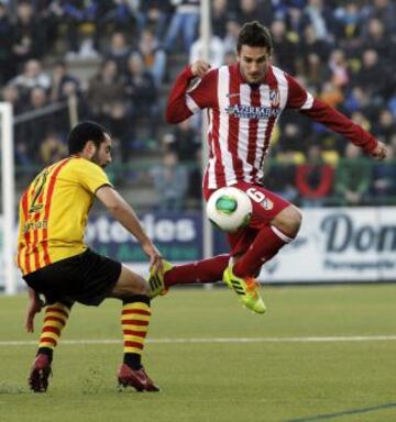 El centrocampista del Atlético de Madrid Koke Resurrección (d) con el balón ante Xapi Arnau (i), jugador del Sant Andreu, durante el partido de ida de los dieciseisavos de final de la Copa del Rey, disputado esta tarde en el estadio Nacís Sala de Barcelona.