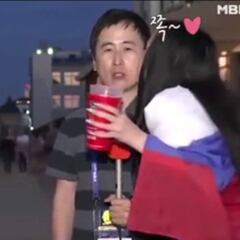 Dos chicas besan a un periodista coreano durante un directo