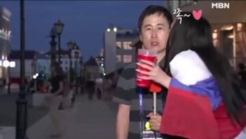 Dos mujeres besan a un periodista coreano durante un directo