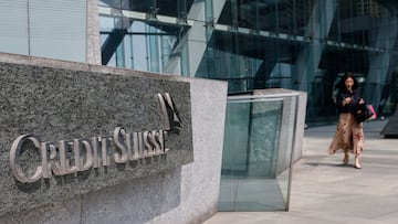 A woman walks near the logo of Credit Suisse outside its office building in Hong Kong, China, March 16, 2023. REUTERS/Tyrone Siu