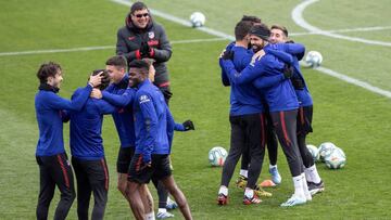 Los jugadores del Atlético bromean con Germán Burgos de fondo.
