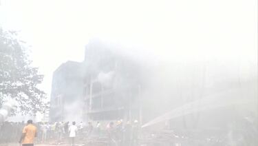 Personal de emergencia trabaja alrededor de un edificio dañado donde se estrelló un avión de Air India en Ahmedabad, India.