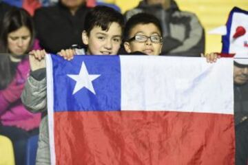 Children with a Chilean flag wait for the Copa America third place football match between Peru and Paraguay in Concepcion, Chile on July 3, 2015.  AFP PHOTO / JUAN BARRETO