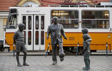 Un conjunto escultórico en homenaje a Ferenc Puskas en Budapest. La estatua principal es el propio Puskas vestido de traje dando toques a un balón mientras le observan unos niños que completan la obra escultórica.