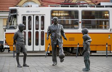 Un conjunto escultórico en homenaje a Ferenc Puskas en Budapest. La estatua principal es el propio Puskas vestido de traje dando toques a un balón mientras le observan unos niños que completan la obra escultórica. 