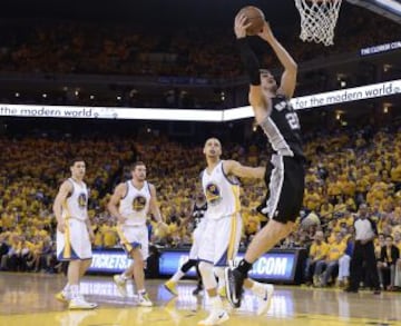 El jugador de los Spurs de San Antonio Tiago Splitter (dcha) entra a canasta ante la mirada de Stephen Curry (2º dcha), de los Warriors de Golden State, durante el sexto partido de la semifinal de la Conferencia Oeste disputado en el pabellón Oracle Arena de Oakland, Californa (Estados Unidos). Los Spurs ganaron por 82-94 para clasificarse para la final.