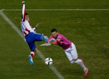 El delantero mexicano del Atlético de Madrid Raúl Jiménez (i) disputa un balón con el portero del L'Hospitalet Carlos Craviotto (d), durante el partido de vuelta de los dieciseisavos de final de la Copa del Rey que se juega esta tarde en el estadio Vicente Calderón.