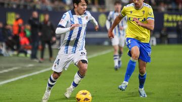 CÁDIZ, 21/12/2023. - El centrocampista japonés de la Real Sociedad Takefusa Kubo (i) se escapa del delantero del Cádiz CF Rubén Sobrino, durante el partido de la jornada 18 de LaLiga que enfrenta al Cádiz CF y a la Real Sociedad este jueves en el Estadio Nuevo Mirandilla. EFE/Román Ríos.
