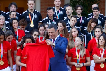 Pedro Sánchez sostiene una camiseta firmada por las integrantes de la Selección española de fútbol femenino.
