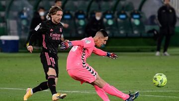 Real Madrid&#039;s Croatian midfielder Luka Modric (L) eyes the ball as Elche&#039;s Spanish goalkeeper Edgar Badia makes a pass during the Spanish League football match between Elche and Real Madrid at the Manuel Martinez Valero stadium in Elche on Decem