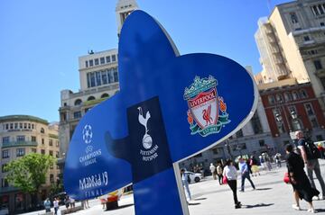 People walk past a sign for the UEFA Champions League final football match between Liverpool and Tottenham Hotspur in Madrid on May 29, 2019. 