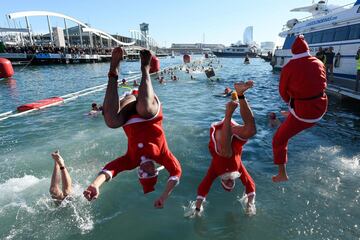 Tradición y diversión entre los nadadores, que compiten en un recorrido de 200 metros con salida y llegada frente a la estatua de Colón en el puerto de Barcelona.
