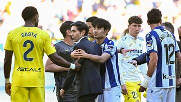 Real Sociedad's Japanese forward #14 Takefusa Kubo (C) holds on to Villarreal's Spanish coach Marcelino Garcia Toral at the end of the Spanish league football match between Villarreal CF and Real Sociedad at La Ceramica Stadium in Vila-real, on April 20, 2025. (Photo by JOSE JORDAN / AFP)