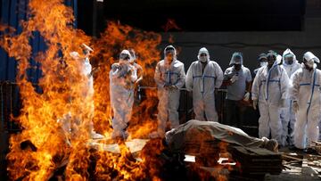 Relatives wearing personal protective equipment (PPE) attend the funeral of a man, who died from the coronavirus disease (COVID-19), at a crematorium in New Delhi, India April 21, 2021. REUTERS/Adnan Abidi