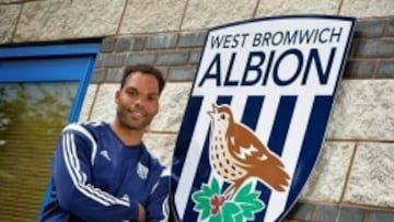 Joleon Lescott posando junto a el escudo de su nuevo equipo.