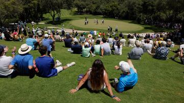 Los aficionados observan a Jon Rahm desde una ladera.
