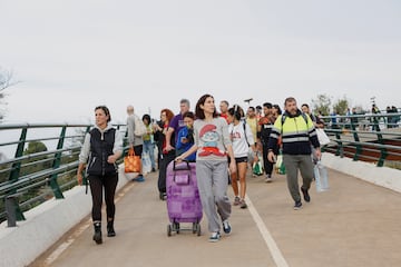 Personas transportan suministros para ayudar a las zonas afectadas por las inundaciones caminan por un camino fangoso, tras las lluvias torrenciales que provocaron inundaciones, en Valencia.