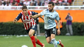 Miguel Ponce (L) of Guadalajara vies for the ball with Juan Vigon (R) of Tigres, during their Mexican Clausura tournament football match, at the Akron stadium, in Guadalajara, Jalisco State, Mexico, on February 12, 2022. (Photo by Ulises Ruiz / AFP)