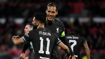 Liverpool's Egyptian forward #11 Mohamed Salah celebrates scoring the opening goal with Liverpool's Dutch defender #04 Virgil van Dijk during the UEFA Champions League, league phase football match between Girona FC and Liverpool FC at the Montilivi stadium in Girona on December 10, 2024. (Photo by Josep LAGO / AFP)