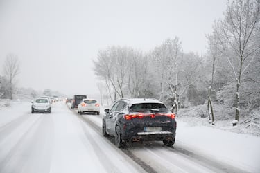 Varios vehículos se quedan parados mientras circulan con la nieve por la M-607.
