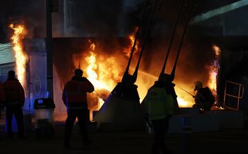 Los bomberos apagan el fuego en un local de venta de merchandising antes del partido entre el Manchester City y el Brujas.