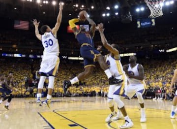 LeBron James, el jugador de los Cavaliers lanza a canasta entre  Stephen Curry, de los  Warriors, y Andre Iguodala durante el segundo partido de la serie final de la NBA 