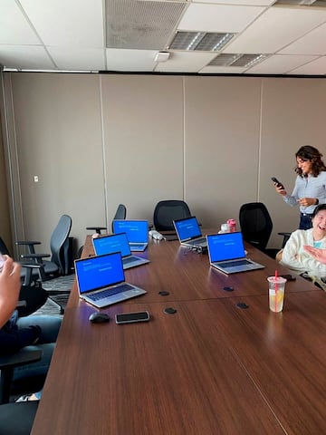 Trabajadores de una oficina muestran sus ordenadores portátiles con la pantalla azul debido al CrowdStrike.