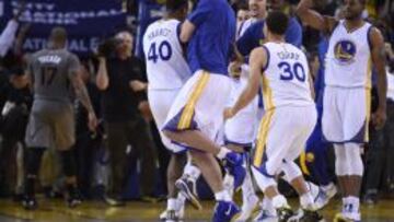 Harrison Barnes es felicitado por sus compañeros David Lee y Stephen Curry.