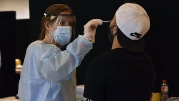 Una trabajadora sanitaria realiza un test de antígenos a un joven.