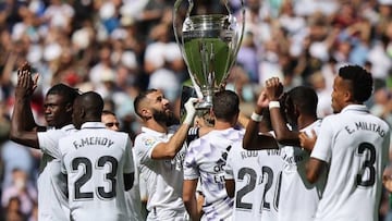 Real Madrid's French forward Karim Benzema (C) and teammates hold the European Champion Clubs' Cup trophy, awarded for winning the UEFA Champions League, on the pitch before the start of the Spanish league football match between Real Madrid CF and Real Betis at the Santiago Bernabeu stadium in Madrid on September 3, 2022. (Photo by Thomas COEX / AFP) (Photo by THOMAS COEX/AFP via Getty Images)