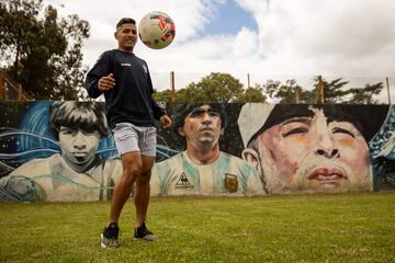 Mural de Diego Armando Maradona en el estadio Juan Carmelo Zerillo del Club de Gimnasia y Esgrima La Plata en  Buenos Aires, Argentina. En la imagen Eric Ramírez, jugador del club, con un balón frente a la pintura.