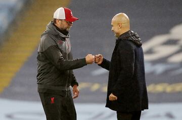 Pep Guardiola and Liverpool manager Juergen Klopp bump fists