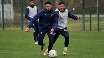 Los rojillos Javi Muñoz y Simón pugnan por el balón durante un entrenamiento.