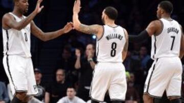 Andray Blatche (0) Deron Williams (8) y Joe Johnson (7) celebran la victoria de su equipo.