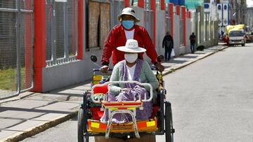 Residents ride a rickshaw in Puno, Peru, near the border with Bolivia, on May 1, 2020, amid the new coronavirus pandemic. - The government has identified markets as major hotspots of the COVID-19 virus. 40,459 cases of coronavirus and 1,124 casualties wer