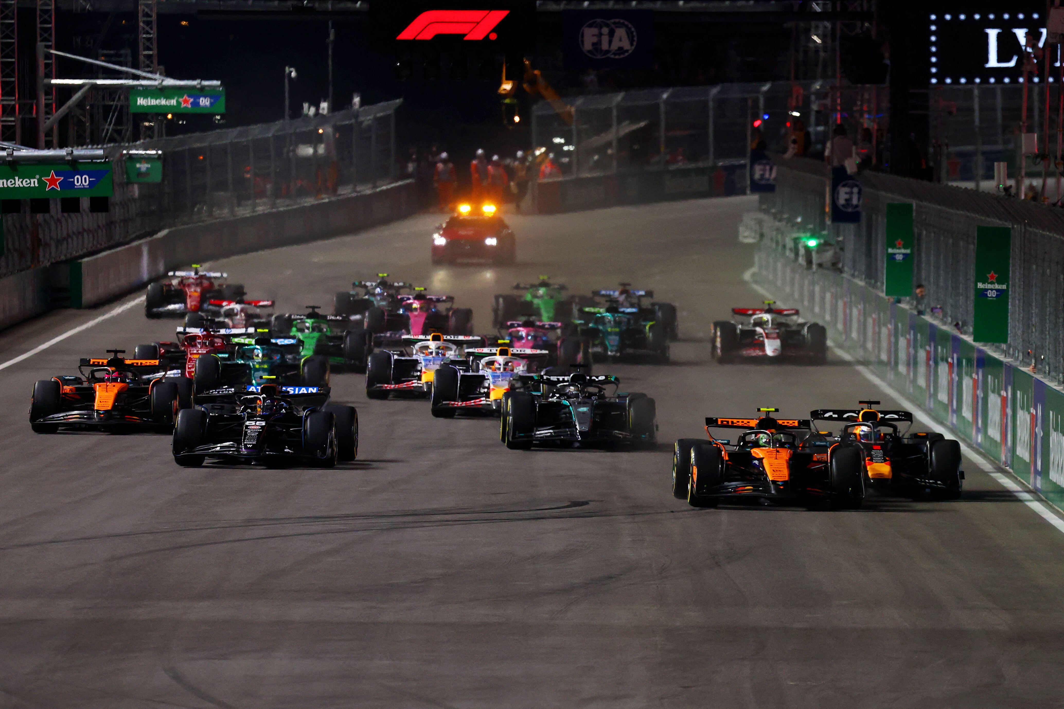 LAS VEGAS, NEVADA - NOVEMBER 22: Lando Norris of Great Britain driving the (4) McLaren MCL39 Mercedes and Max Verstappen of the Netherlands driving the (1) Oracle Red Bull Racing RB21 battle for track position at the race start during the F1 Grand Prix of Las Vegas at Las Vegas Strip Circuit on November 22, 2025 in Las Vegas, Nevada.   Mark Thompson/Getty Images/AFP (Photo by Mark Thompson / GETTY IMAGES NORTH AMERICA / Getty Images via AFP)