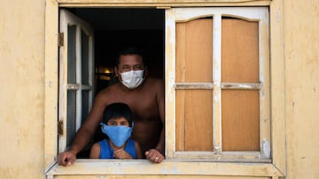 Residents at the El Diablo community close to the northern city of Piura, 1,000 kilometers north of Lima, watch from their windows as Authorities register residents taking food donations to 150 poor families stuck in their homes on April 27, 2020 during t