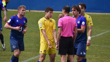Jugadores de ambos equipos rodean al árbitro durante el encuentro que enfrentó al CD Móstoles URJC y a la AD Alcorcón B en el estadio de El Soto, correspondiente a la Jornada 20 en el Grupo 7-B de Tercera División.